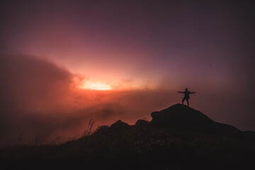 Silhouette of a person above the clouds - 425243974