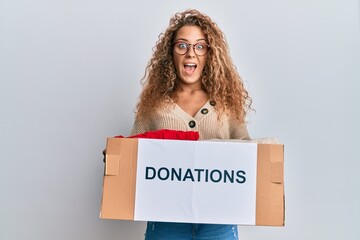 Beautiful caucasian teenager girl volunteer holding donations box celebrating crazy and amazed for success with open eyes screaming excited.