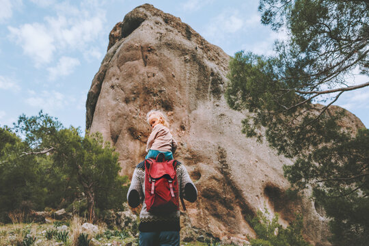 Family travel lifestyle father and daughter child sitting on shoulders outdoor hiking in rocky mountains active vacations together with baby