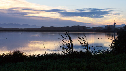 The dawn sky is reflected in a lake in the False Bay Nature Reserve in Cape Town, South Africa.
