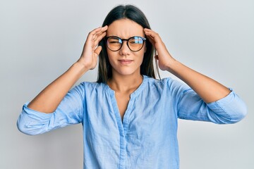 Young hispanic girl wearing casual clothes and glasses with hand on head, headache because stress. suffering migraine.