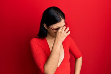 Young latin woman wearing casual clothes and glasses tired rubbing nose and eyes feeling fatigue and headache. stress and frustration concept.