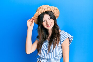Young beautiful caucasian girl wearing summer hat looking to side, relax profile pose with natural face and confident smile.