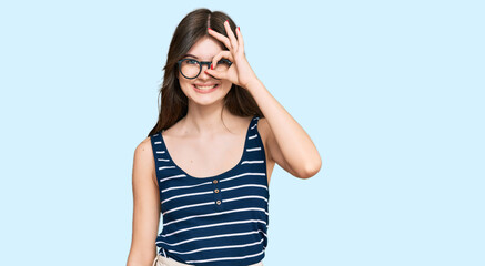 Obraz na płótnie Canvas Young beautiful caucasian girl wearing casual clothes and glasses doing ok gesture with hand smiling, eye looking through fingers with happy face.