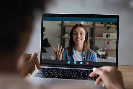 Close up rear view of female employee have webcam digital virtual call on laptop with coworker colleague. Biracial woman speak talk on video conference with business partner. Zoom concept.