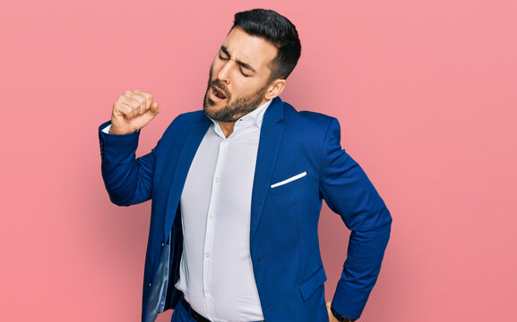 Young hispanic man wearing business jacket stretching back, tired and relaxed, sleepy and yawning for early morning