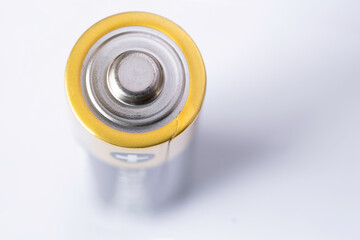 Close-up of an upright penlight battery on white, focus on the battery head. Narrow depth of field