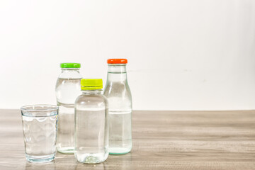 Several bottles of water on wooden table.