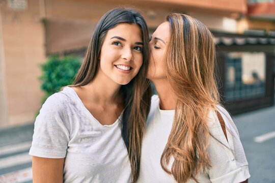 Beautiful hispanic mother and daughter smiling happy standing at the city.