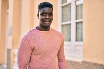 Young african american man smiling happy standing at the city.