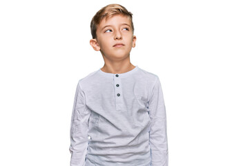 Little caucasian boy kid wearing casual clothes smiling looking to the side and staring away thinking.