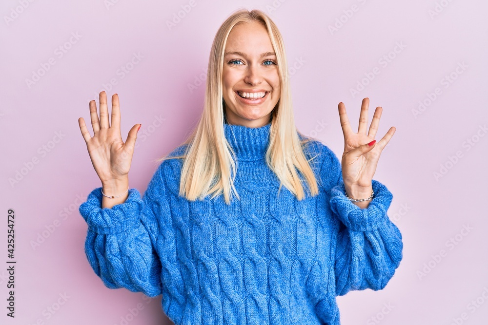 Sticker young blonde girl wearing wool winter sweater showing and pointing up with fingers number nine while