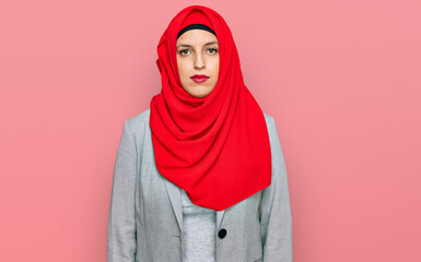 Beautiful hispanic woman wearing traditional islamic hijab scarf with serious expression on face. simple and natural looking at the camera.