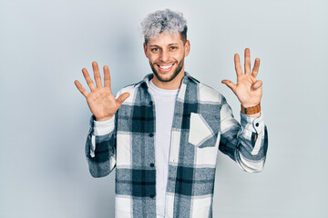 Young hispanic man with modern dyed hair wearing casual shirt showing and pointing up with fingers...