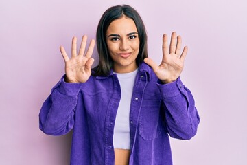 Young brunette woman wearing casual clothes showing and pointing up with fingers number nine while...