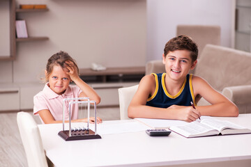 Fototapeta premium Schoolboy and his small sister staying at home during pandemic