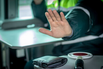 Street lighting. A special car inspector shows a hand gesture. On the table is a wallet and a red...