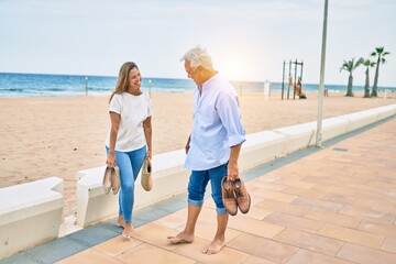 Middle age hispanic couple smiling happy walking at the promenade © Krakenimages.com