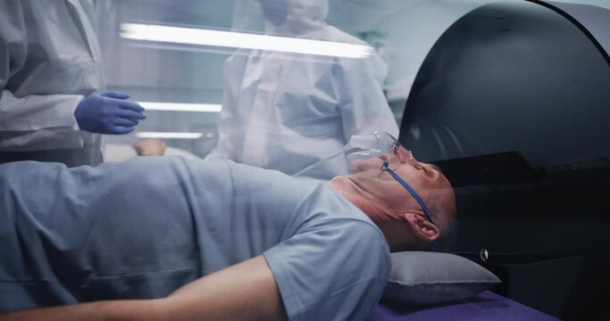 Medical practitioners speaking near heavily breathing aged patient