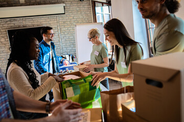 Group of volunteers with working in community charity donation center.