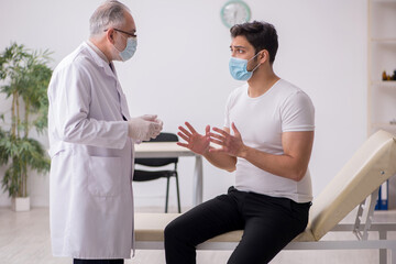 Fototapeta premium Young male patient visiting old male doctor in vaccination conce