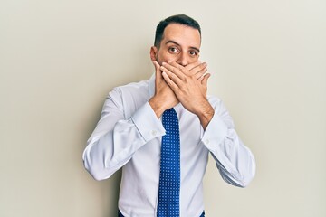 Young man with beard wearing business tie shocked covering mouth with hands for mistake. secret concept.