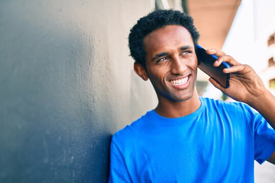 Handsome black african man smiling happy outdoors speaking on the phone