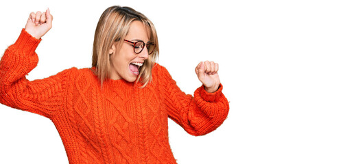 Beautiful blonde woman wearing casual clothes and glasses dancing happy and cheerful, smiling...
