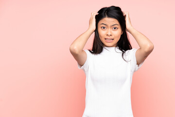 Teenager Chinese woman isolated on pink background doing nervous gesture