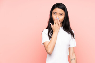 Teenager Chinese woman isolated on pink background covering mouth with hand