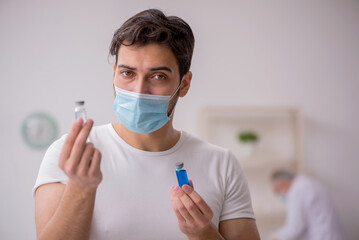 Young male patient visiting old male doctor in vaccination conce