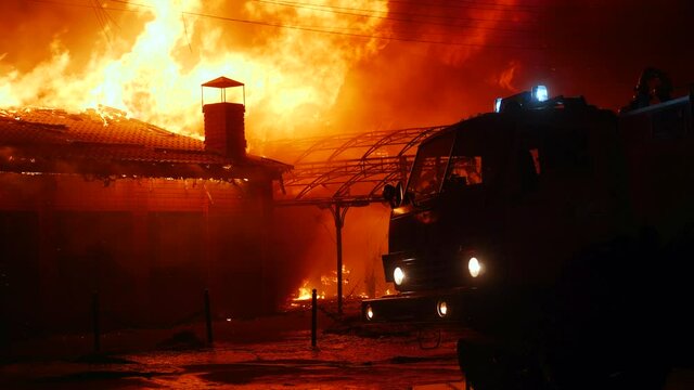 fire truck and flasher fire engine. fire on the roof of the house. a burning at building house . home insurance apartment concept. huge night fire blazes houses 911. property damage arson protection