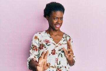 Young african american girl wearing casual clothes disgusted expression, displeased and fearful doing disgust face because aversion reaction. with hands raised