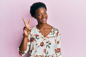 Young african american girl wearing casual clothes showing and pointing up with fingers number two while smiling confident and happy.