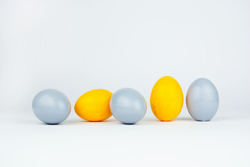 Five easter trendy colored classic yellow and gray decorated eggs on white background. Happy Easter