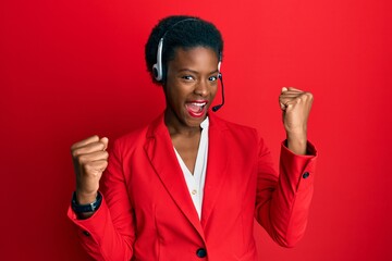 Young african american girl wearing call center agent headset screaming proud, celebrating victory...