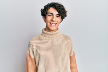Hispanic young man wearing casual winter sweater with a happy and cool smile on face. lucky person.