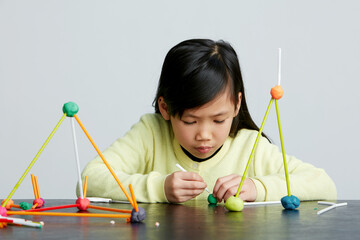 Cute Asian little girl playing experimental creation