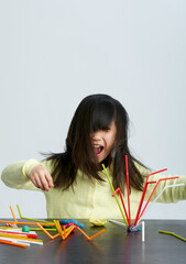 Cute Asian little girl playing experimental creation