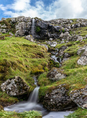 Creek waterfall under the clouds, Faroe Islands.