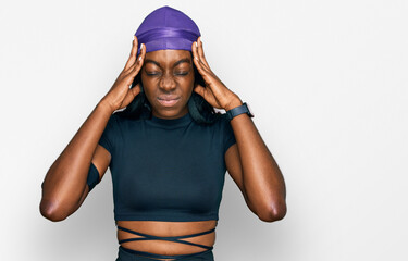 Young african american woman wearing sportswear suffering from headache desperate and stressed because pain and migraine. hands on head.