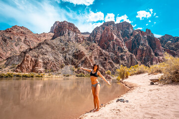 A young woman celebrating that they have finished the descent of the South Kaibab Trailhead trekking in the river bathing. Grand canyon.