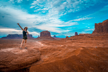 A young woman in a black T-shirt at John Ford's Point looking at the Monument Valley. Utah.