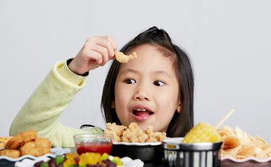 Cute Asian little girl eating happily
