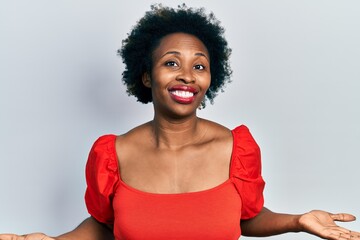 Young african american woman wearing casual clothes clueless and confused expression with arms and hands raised. doubt concept.