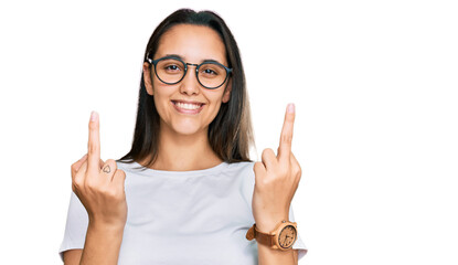 Young hispanic woman wearing casual white t shirt showing middle finger doing fuck you bad expression, provocation and rude attitude. screaming excited