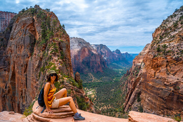 A young woman on top of the trekking of the Angels Landing Trail in Zion National Park, Utah....