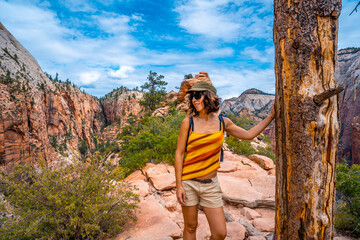 Naklejka premium A young woman on top of the trekking of the Angels Landing Trail in Zion National Park, Utah. United States.