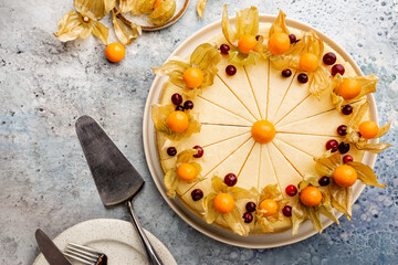 Classic New York cheesecake with fresh berries on light blue concrete background, top view