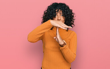 Young hispanic woman wearing casual clothes doing time out gesture with hands, frustrated and...